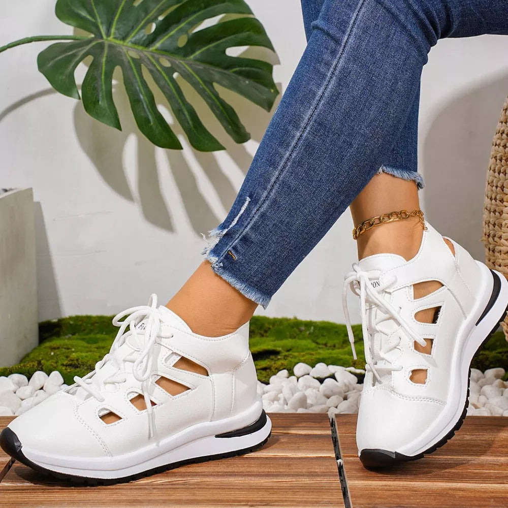 Chic white round toe lace-up sneakers with cut-out details and a black sole.