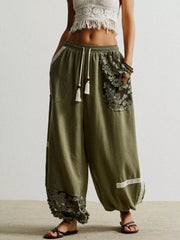 Moss harem pants with drawstring, lace trim, and floral embroidered pockets.