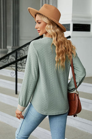 Sage green textured V-neck blouse with embroidered cuff detail