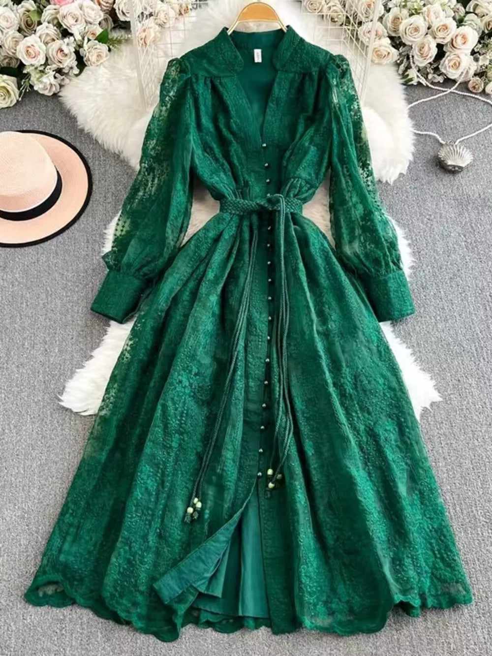 Green lace maxi dress with tie waist, V-neck, balloon sleeves, and button front.