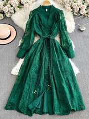Green lace maxi dress with tie waist, V-neck, balloon sleeves, and button front.