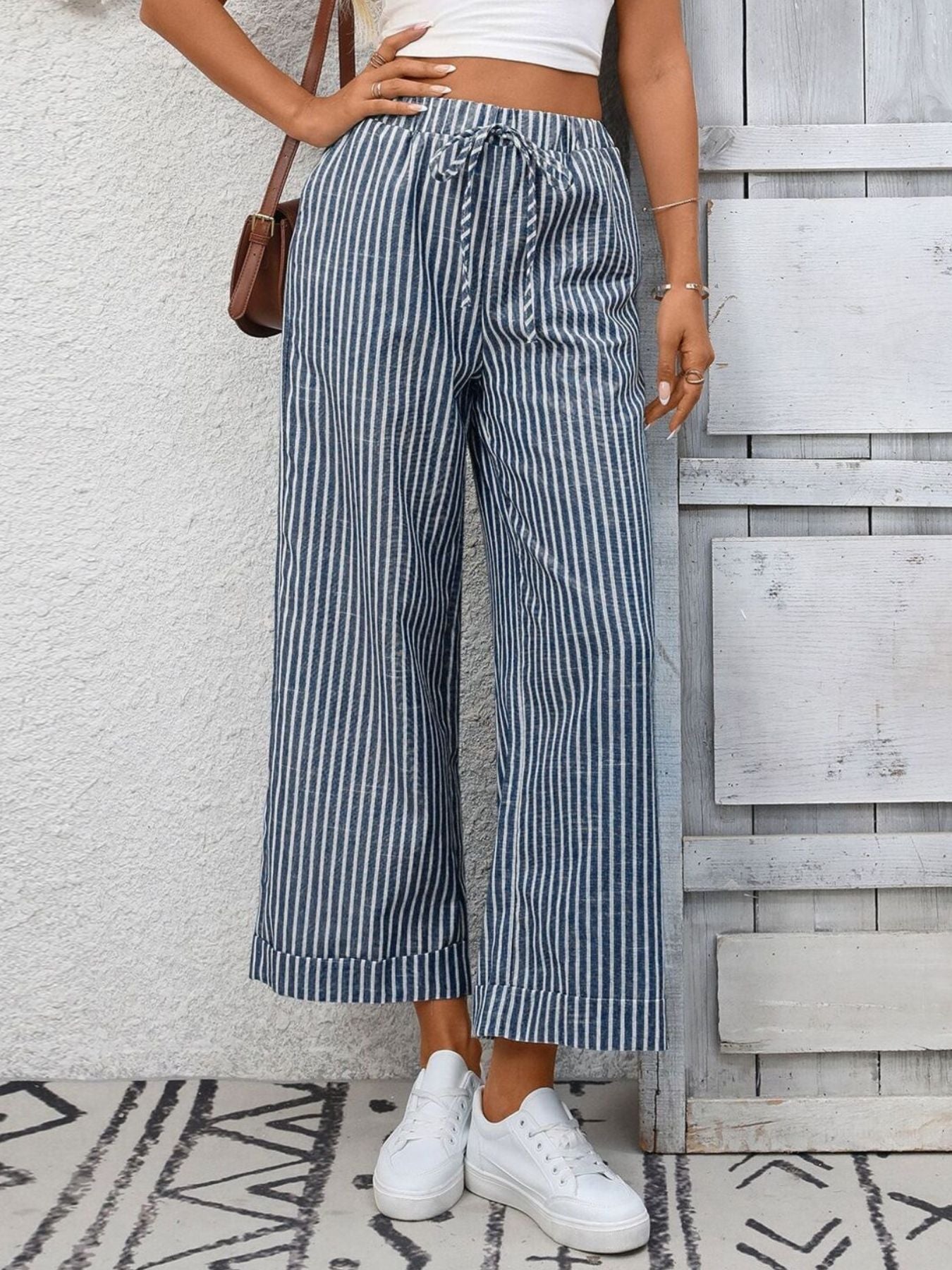 Navy blue and white striped wide leg pants with drawstring waist and pockets.