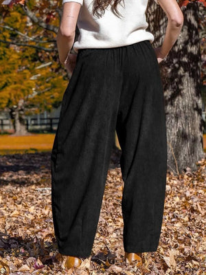 Black corduroy wide-leg pants with pockets and an elastic waistband.