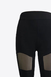 Black leggings with geometric mesh panels on the legs.