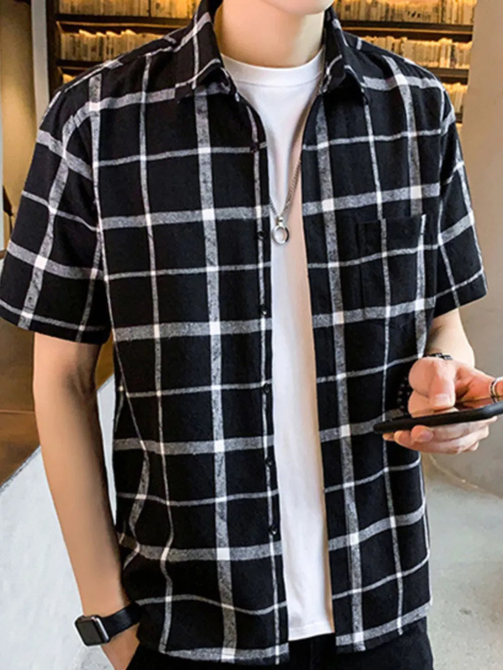 Men's black and white plaid short sleeve button-down shirt with chest pocket.