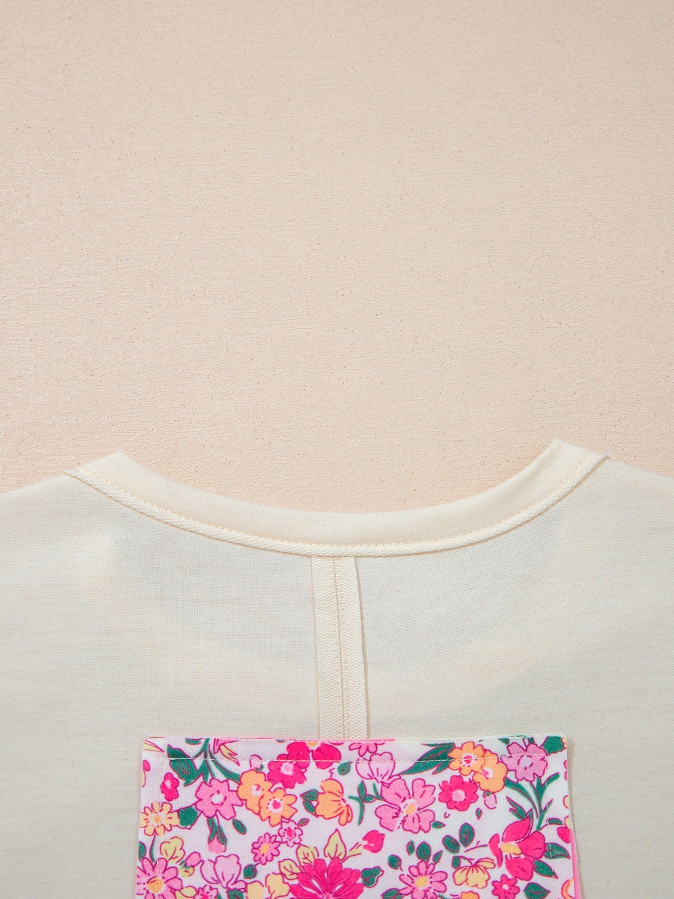 Cream cotton crew neck t-shirt with a colorful floral chenille patch pocket detail.