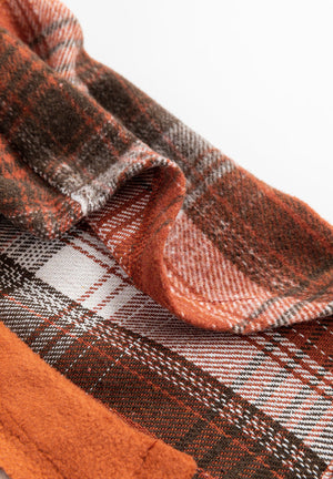 Colorblock plaid shacket in terracotta with contrast cuffs and button detail.