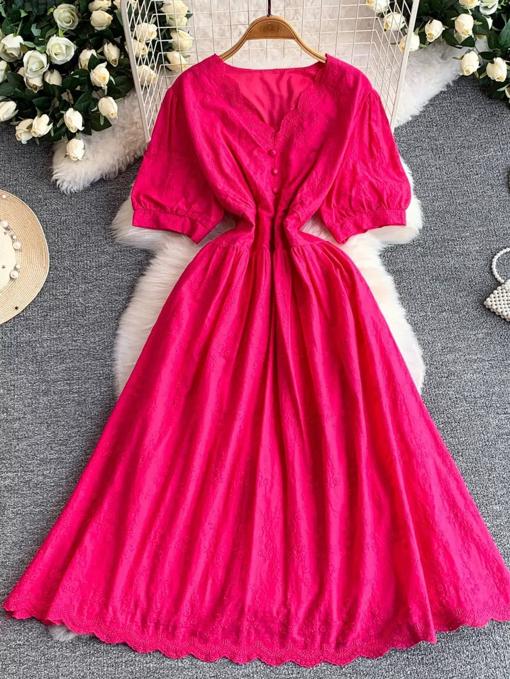 Pink lace-embellished A-line midi dress with V-neck, puff sleeves, and button front.
