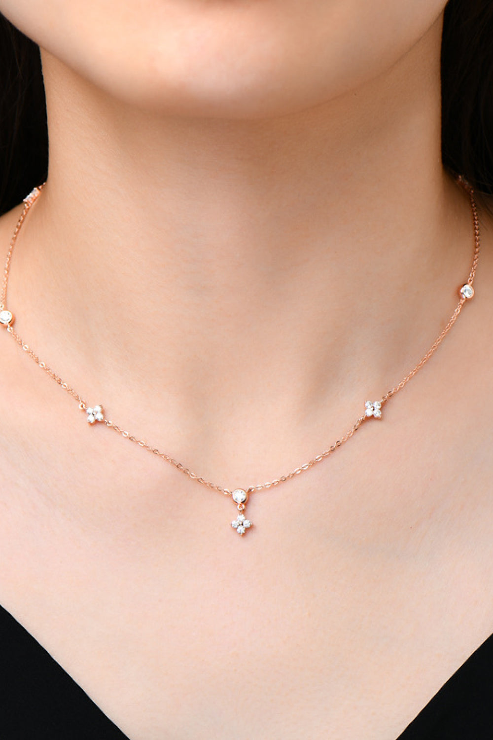 Rose gold necklace with diamond cluster pendant and scattered diamond accents.
