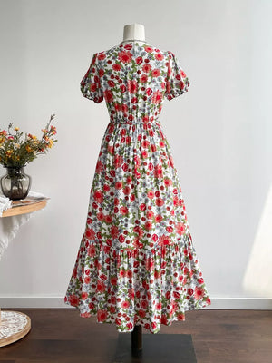 Vibrant floral midi dress with V-neck, short sleeves, elastic waist, and tiered hem.