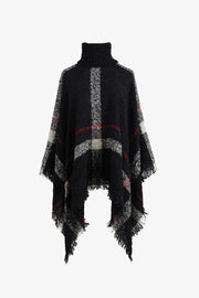Black plaid turtleneck cape with fringe detail and textured acrylic knit.