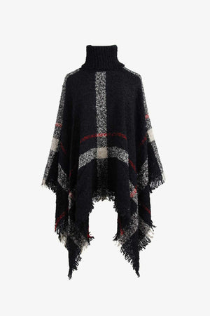 Black plaid turtleneck cape with fringe detail and textured acrylic knit.
