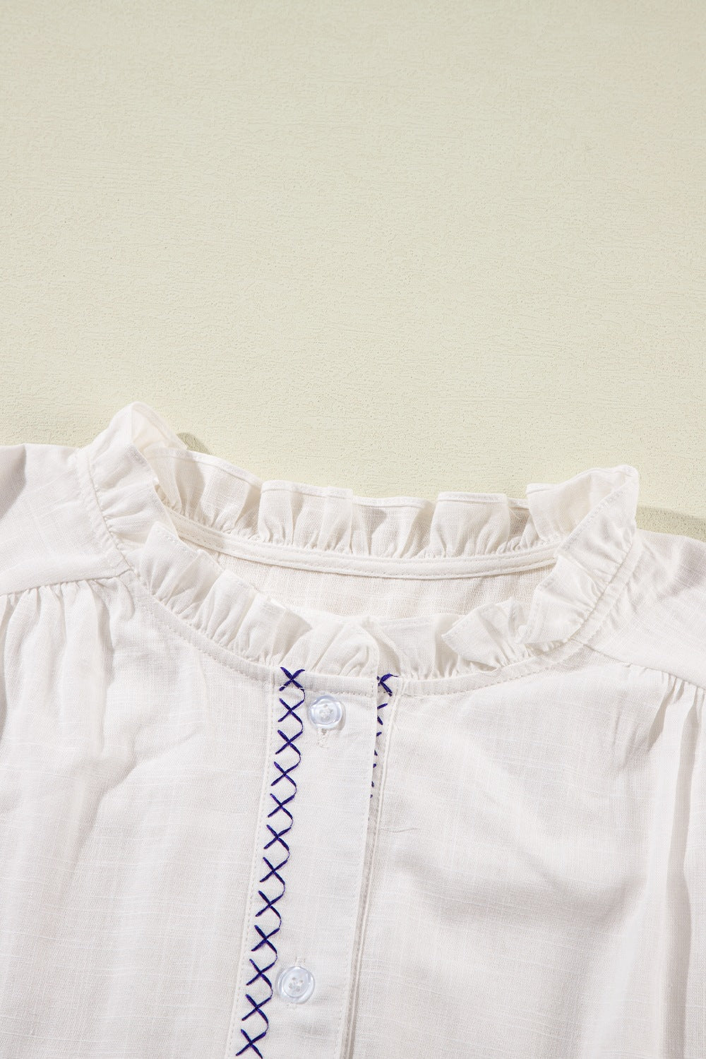 White embroidered blouse with ruffled neckline and button front