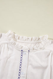 White embroidered blouse with ruffled neckline and button front