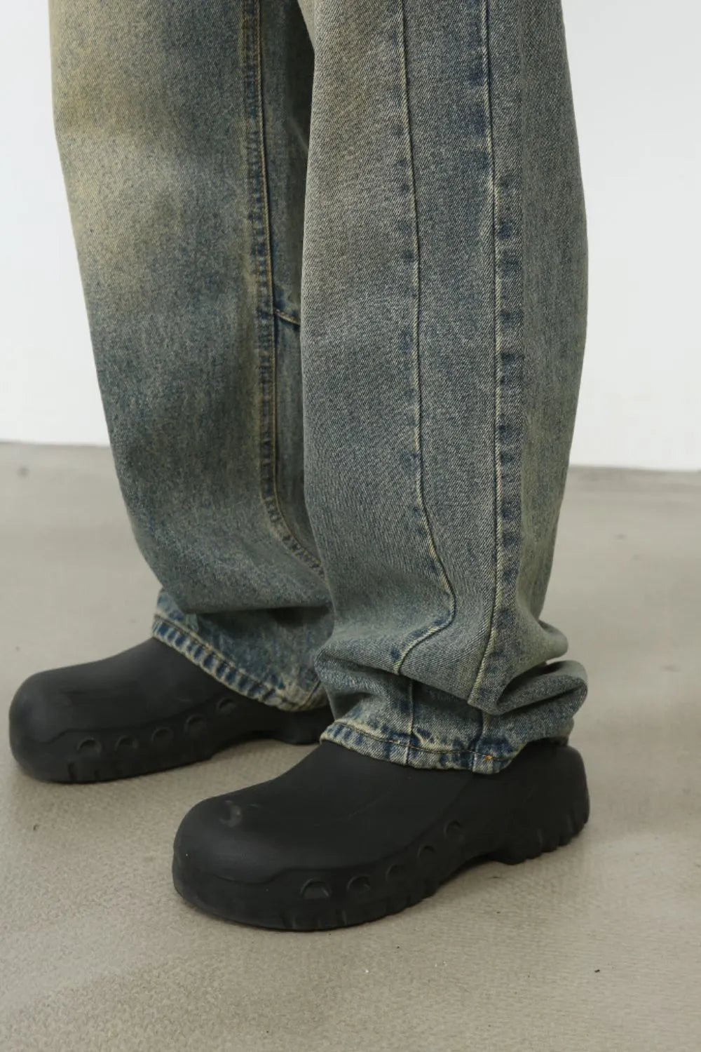 Faded wash baggy carpenter jeans in medium, showing a close-up of the leg and shoe detail.