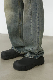 Faded wash baggy carpenter jeans in medium, showing a close-up of the leg and shoe detail.