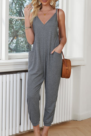 Mid gray jersey jumpsuit with V-neck, spaghetti straps, and slouch pockets.