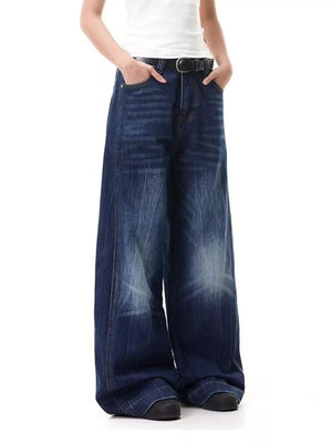 Belted wide leg jeans in washed blue denim with a relaxed fit and visible stitching detail.