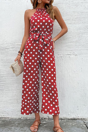 Red polka dot halter neck palazzo jumpsuit with a belted waist.