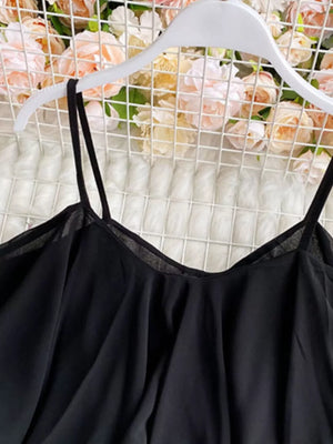 Black ruffled camisole with spaghetti straps and a delicate neckline detail.