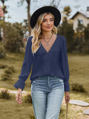 Navy textured blouse with lace trim neckline and ruffled cuffs.