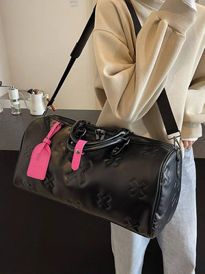 Black embossed cross detail luxury duffel bag with pink accents.