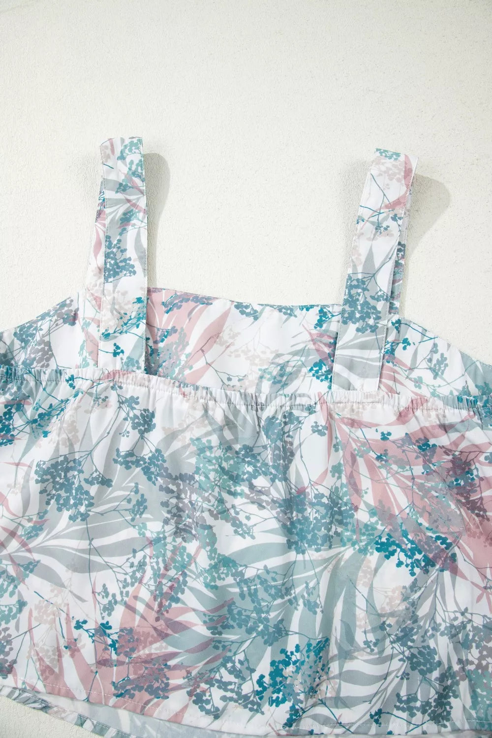 Botanical print maternity one-piece swimsuit with adjustable straps and smocked neckline.