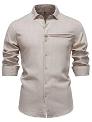 Light gray linen shirt with buttoned front, collar, and pleated pocket detail.