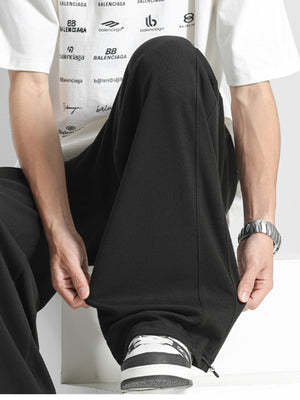 Men's black loose fit sweatpants with a textured fabric detail.