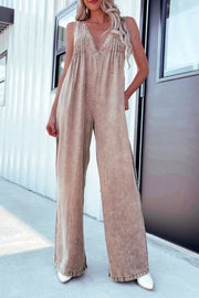 Khaki denim wide-leg jumpsuit with pleated bodice and ruffled hem.
