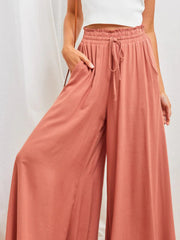 Coral gathered waist wide-leg palazzo pants with drawstring and pockets.