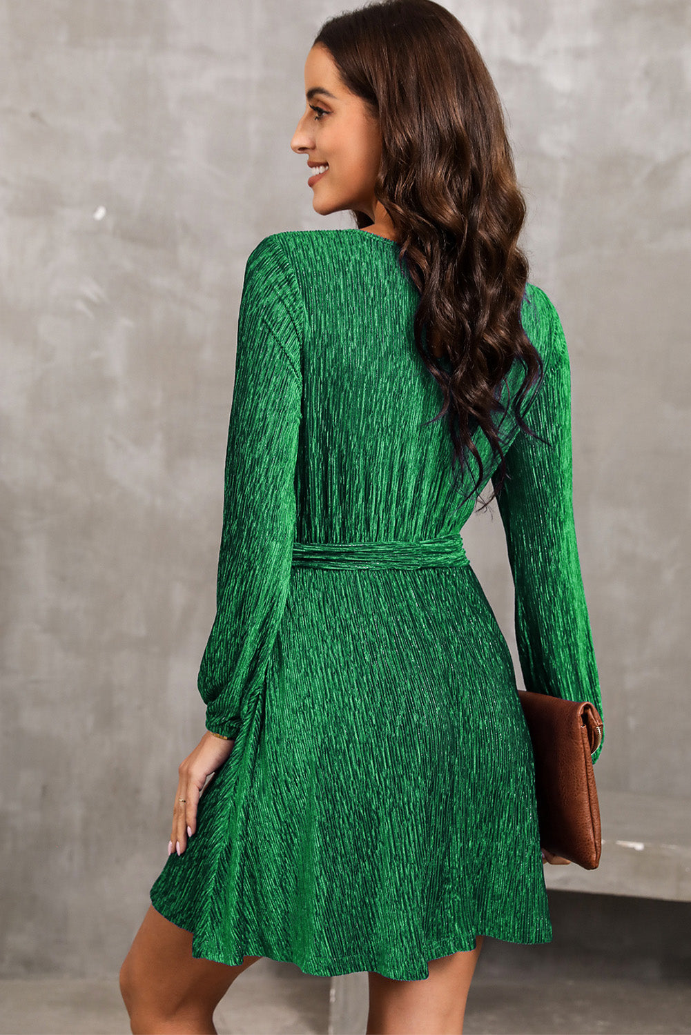 Green textured pleated mini dress with long sleeves and a tie waist.