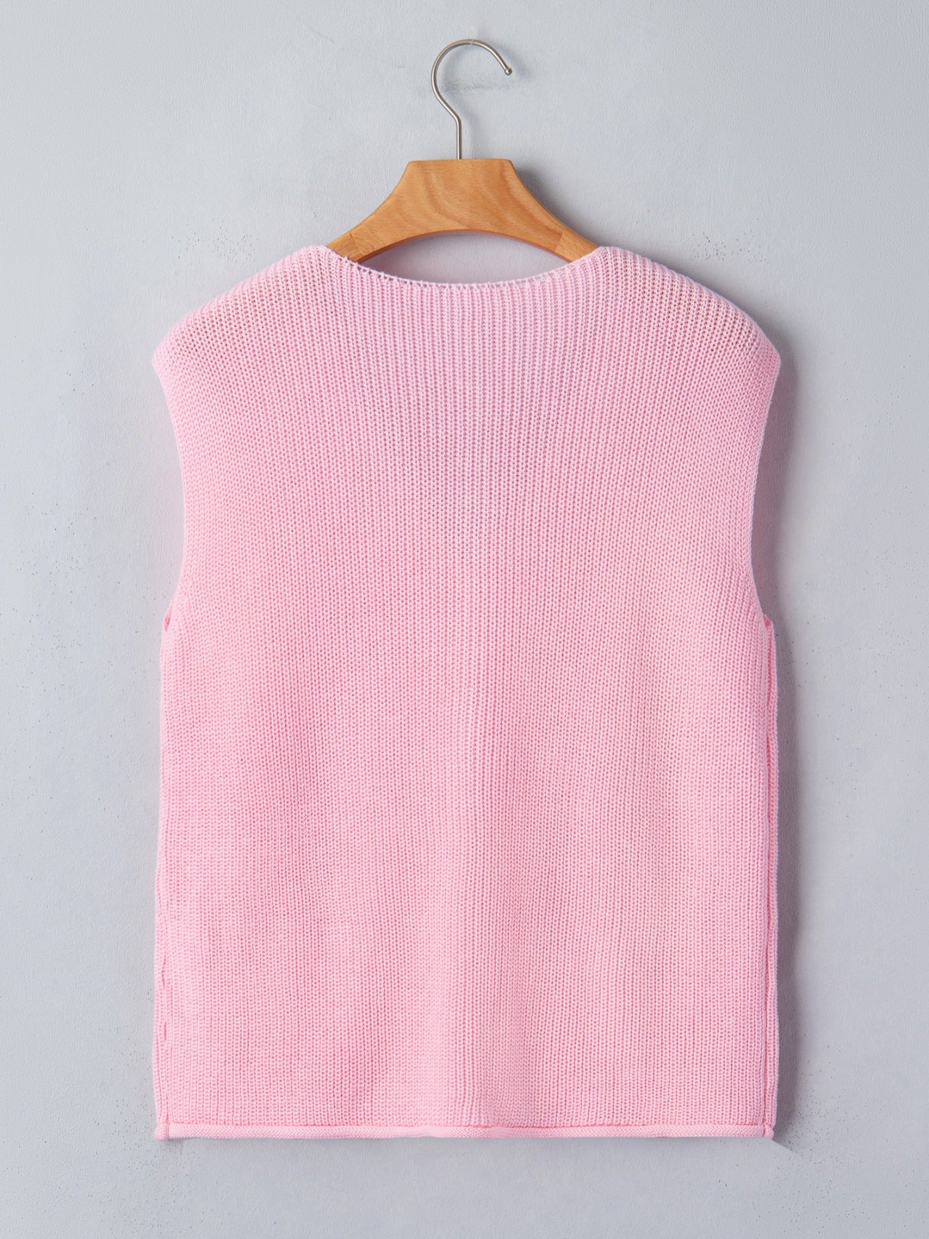 Pink acrylic V neck sweater vest with button front detail.