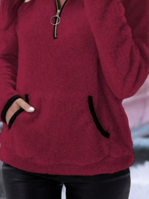 Wine red fleece quarter zip pullover with black trim pocket details.