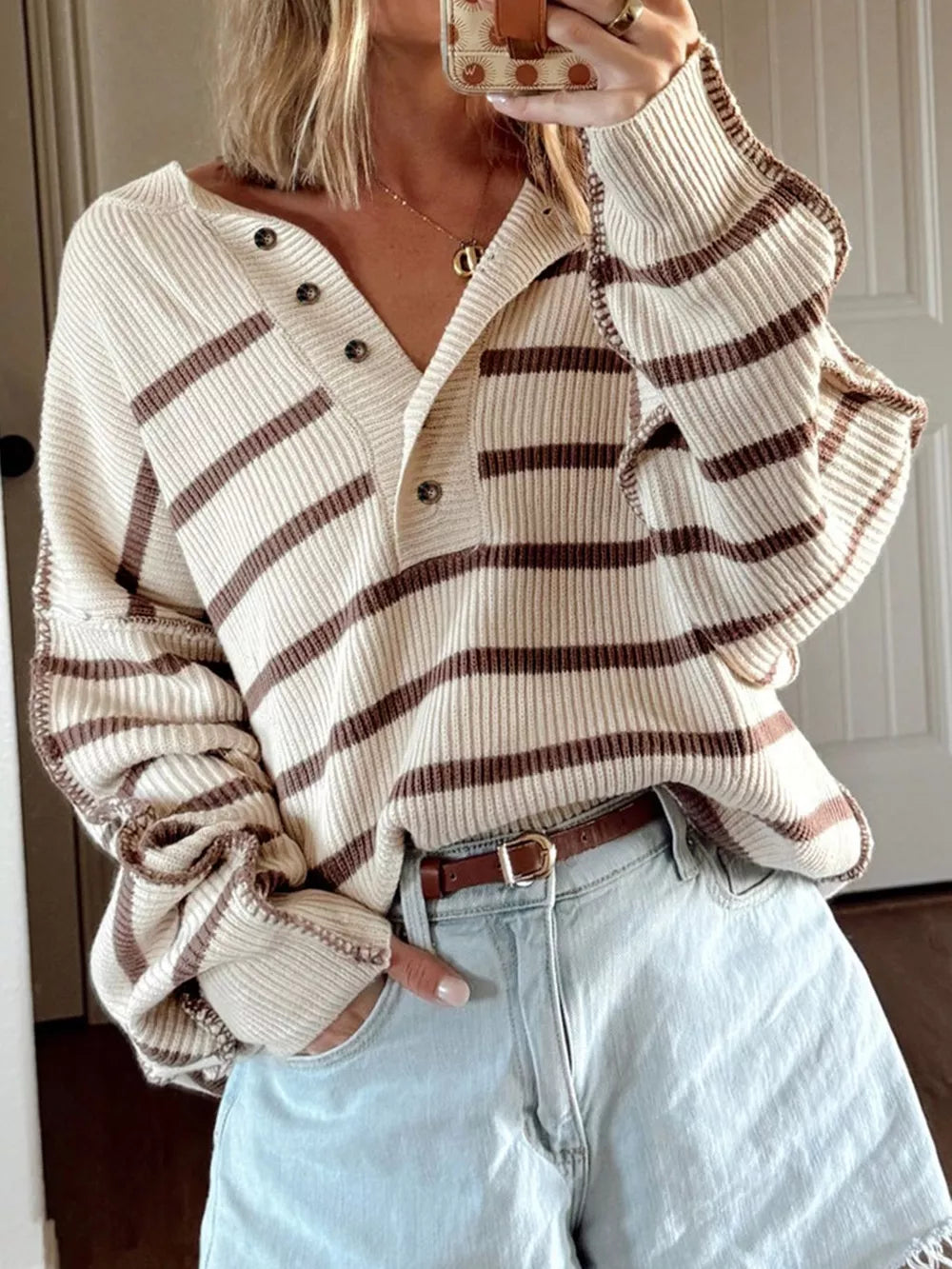 Casual beige striped knit henley sweater with button detail and relaxed fit.