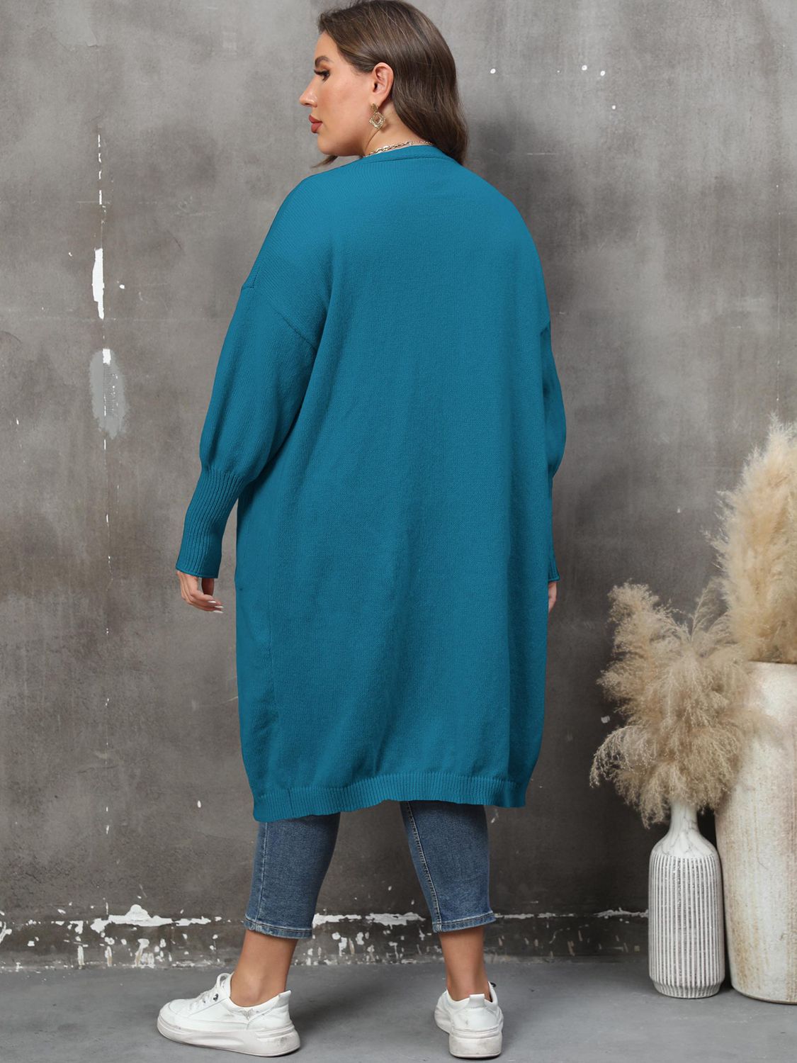 Teal oversized knit duster cardigan with patch pockets and ribbed cuffs.