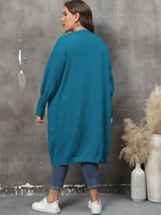Teal oversized knit duster cardigan with patch pockets and ribbed cuffs.