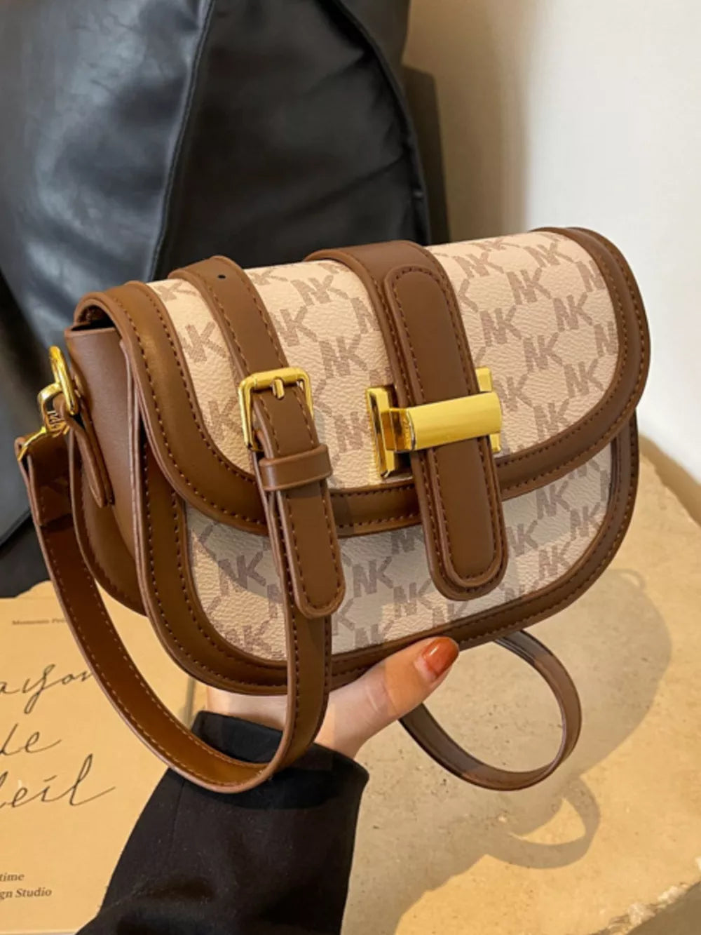 Chic monogrammed flap crossbody bag in beige and brown with gold hardware.