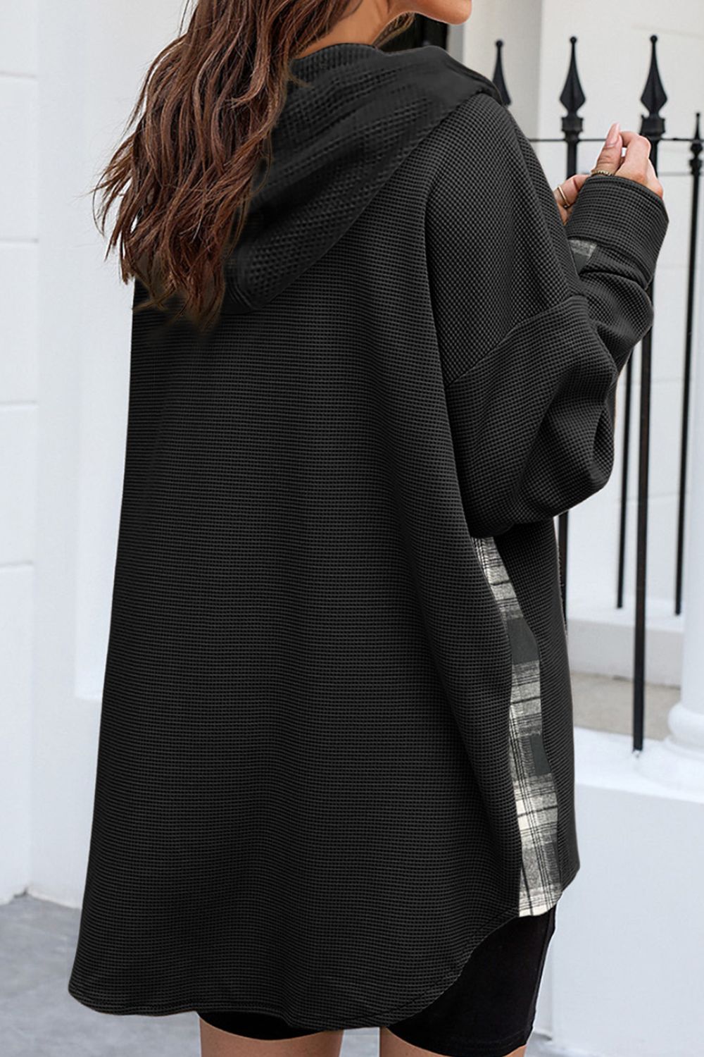Black waffle knit shacket with plaid trim detail on the side, hooded.