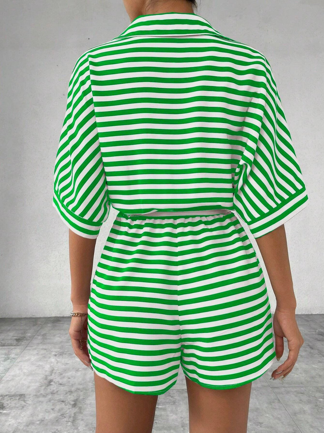 Green and white striped romper with short sleeves and elastic waist shorts.