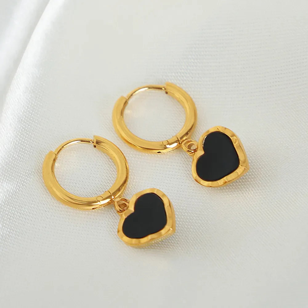 Gold hoop earrings with black enamel heart charms