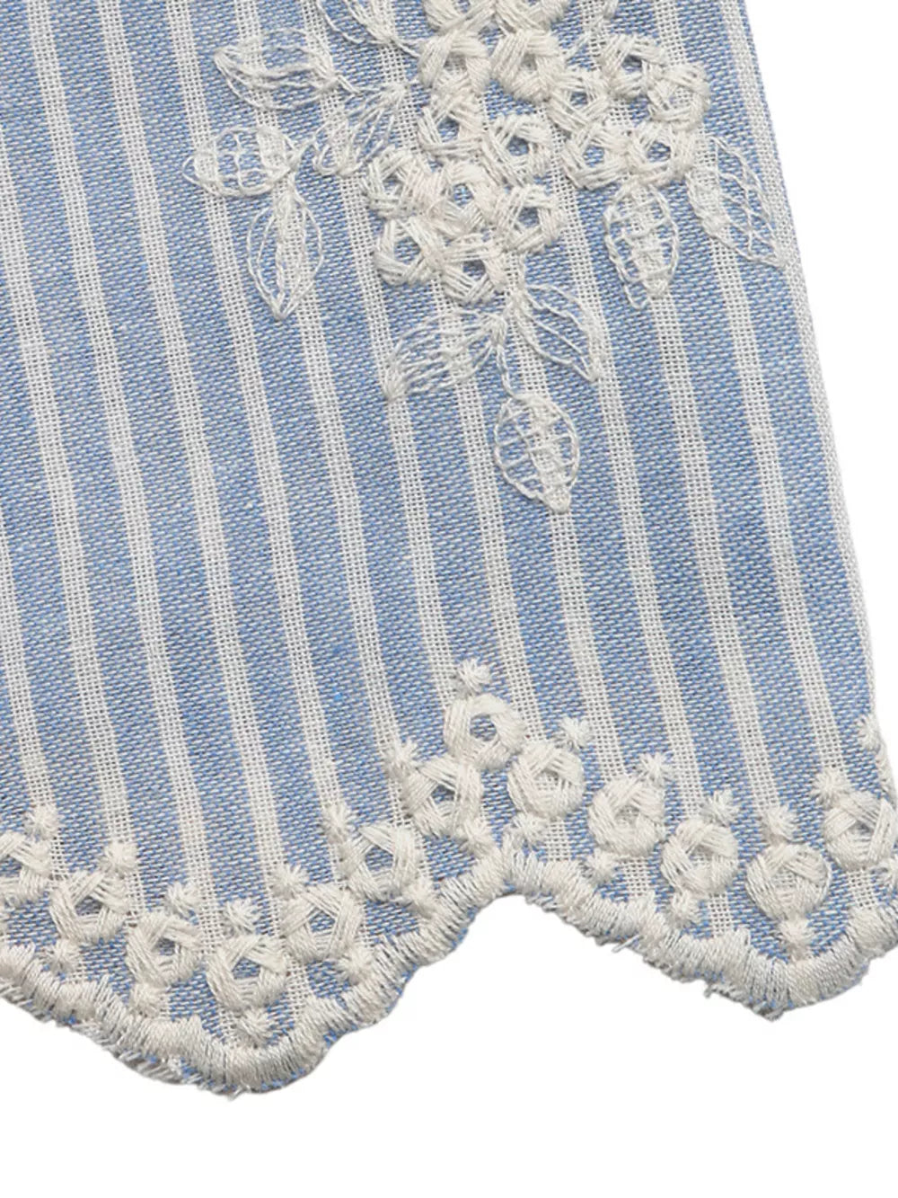 Blue and white striped peplum shirt with white floral embroidery and ruffled hem.