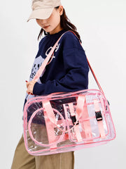 Chic clear PVC travel bag with pink accents and adjustable strap.