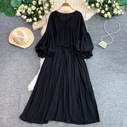 Black bohemian maxi dress with V-neck, cinched waist, and balloon sleeves.
