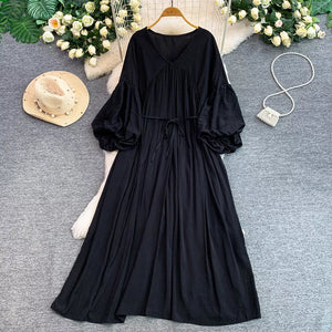 Black bohemian maxi dress with V-neck, cinched waist, and balloon sleeves.