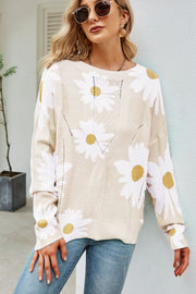 Beige intarsia knit sweater with white daisies, long sleeves, and open knit details.