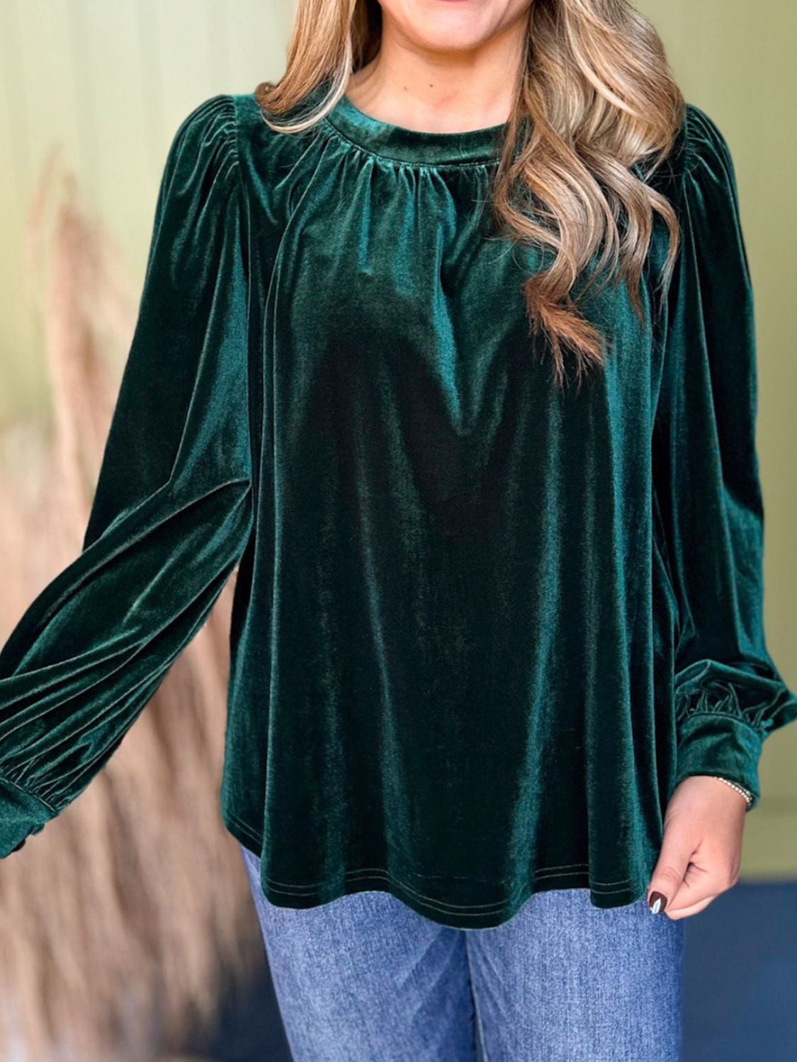 Dark green velvet ruched long sleeve blouse with gathered neckline and cinched cuffs.