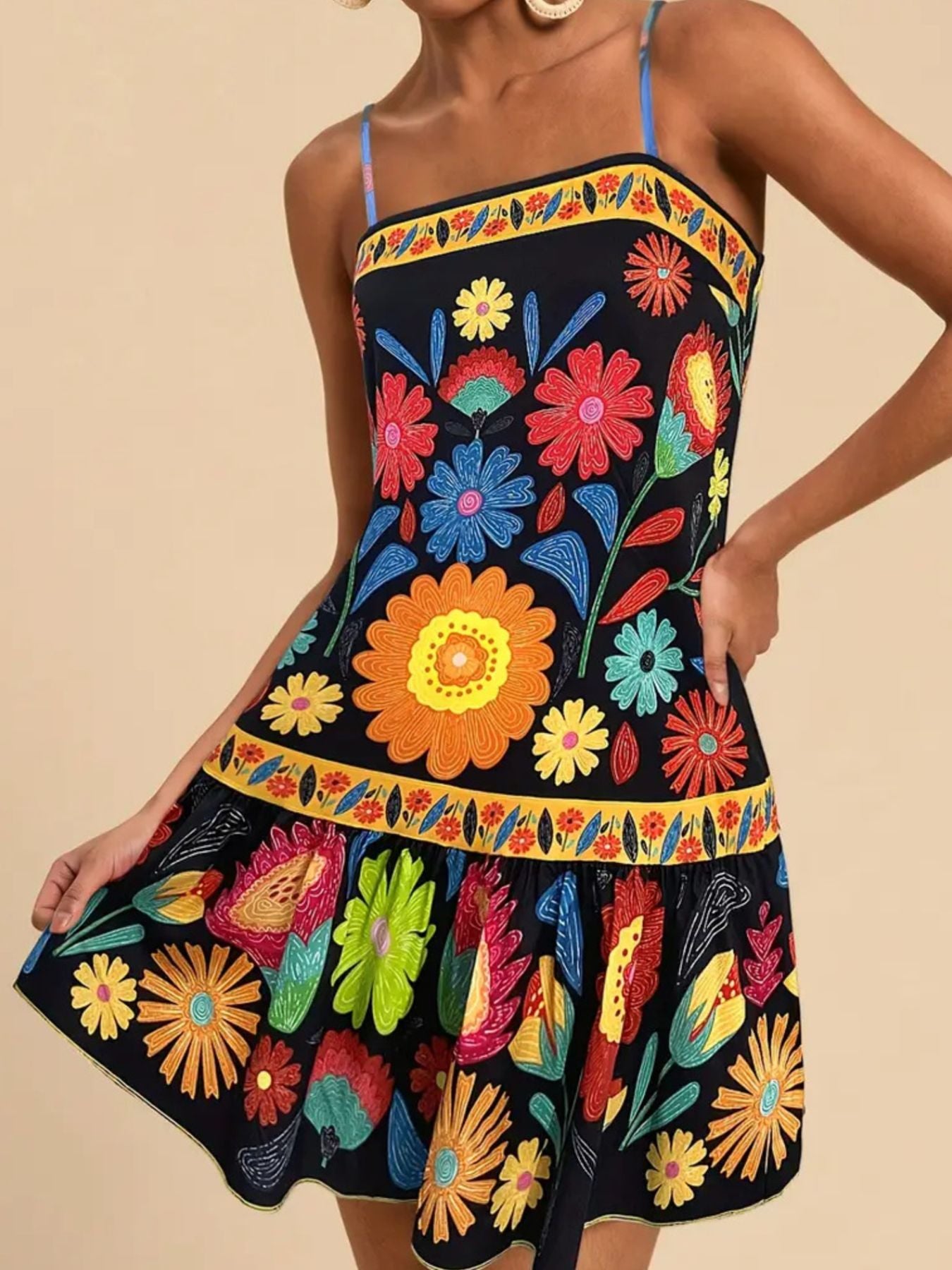 Black mini dress with vibrant floral print, yellow border trim, and spaghetti straps.