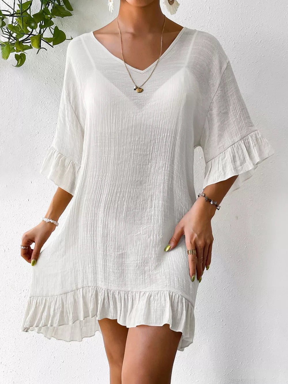 White ruffled V-neck cover-up dress with bell sleeves and textured fabric.