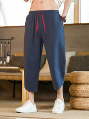 Navy blue cropped sweatpants for men with red drawstring and cuffed hems.